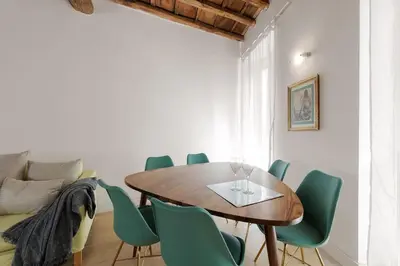 a dining room with a wooden table and green chairs at NEW! Design apartment 2 min from Spanish Steps in Rome