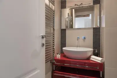 a bathroom with a large white sink on a red counter at NEW! Design apartment 2 min from Spanish Steps in Rome