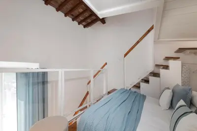 a room with a staircase with a blue couch at Manara flats in the Heart of Trastevere in Rome