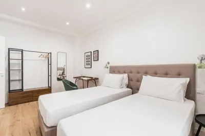 two beds in a room with white walls at The Best Rent - Spacious three-bedroom apartment in Prati area in Rome