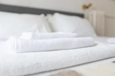 a stack of white towels on a bed at B&B Del Mercato in Rome