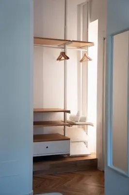 a room with white walls and a wooden shelf at Emma Bliss Apartment in Rome