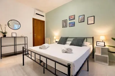 a bedroom with a white bed with towels on it at 2BR Flat by Metro - 6min to Colosseo - Full Kitchen - Wi-Fi - A-C in Rome