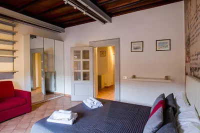 a bedroom with a bed and a red couch at PANTHEON LARGE APARTMENT IN THE HEART OF ROME s in Rome