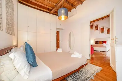 a bedroom with a bed and a living room at PANTHEON 2 - LARGE APARTMENT IN THE HEARTH OF ROME a in Rome