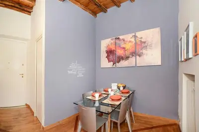 a dining room with a glass table and chairs at PANTHEON 2 - LARGE APARTMENT IN THE HEARTH OF ROME a in Rome