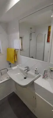 a white bathroom with a sink and a mirror at Casa Argia in Rome