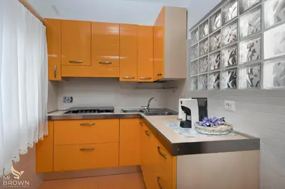 a kitchen with orange cabinets and a sink at Garden and Relax in Rome