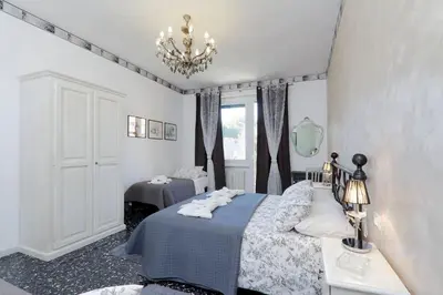 a bedroom with a bed and a chandelier at Apartment Marrucini in Rome