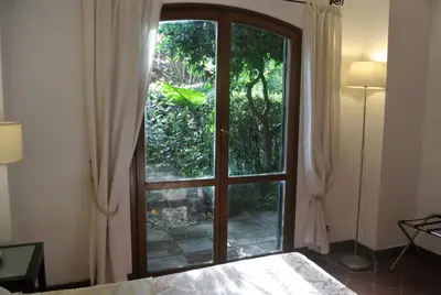 a bedroom with a door open to a garden at Appartamento Garden Palatino in Rome