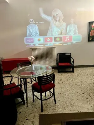 a table and chairs in a room with a screen at Spacious Studio in Via dei Coronari in Rome