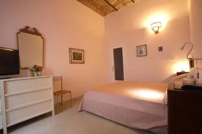 a bedroom with a bed and a dresser with a mirror at Manara Holiday House in Rome