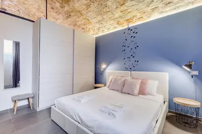 a bedroom with a white bed and blue walls at FaMa - Le Volte in Rome