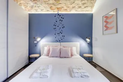 a bedroom with a white bed and blue walls at FaMa - Le Volte in Rome