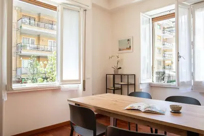 a dining room with a wooden table and two windows at Carpegna Park Apartment by Cornelia subway in Rome