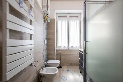 a bathroom with a toilet and a sink and a window at Carpegna Park Apartment by Cornelia subway in Rome