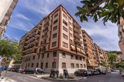 a tall building with cars parked in a parking lot at Vatican Cartographer in Rome