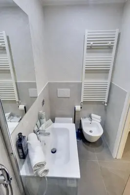 a white bathroom with a sink and a toilet at V Collection Rome Jubilee Guest House in Rome
