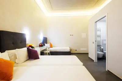 a hotel room with two beds and a bathroom at V Collection Vatican Jubilee Guest House in Rome