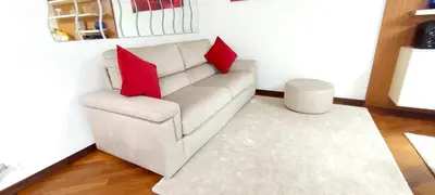 a white couch with two red pillows in a living room at Colosseo Dream in Rome