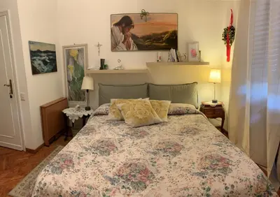 a bedroom with a bed with a floral bedspread at A Casa di Silvana in Rome