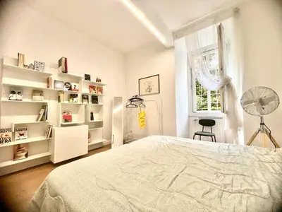 a white bedroom with a bed and a window at The Stylish at Ponte Milvio in Rome