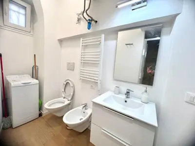a white bathroom with a sink and a toilet at The Stylish at Ponte Milvio in Rome