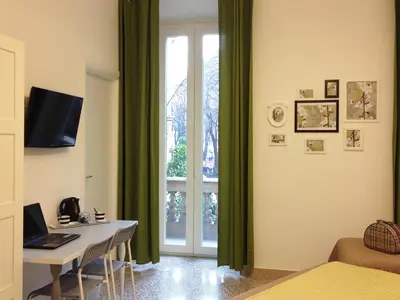 a bedroom with a desk with a laptop and a window at Domò Vaticano Guest House in Rome