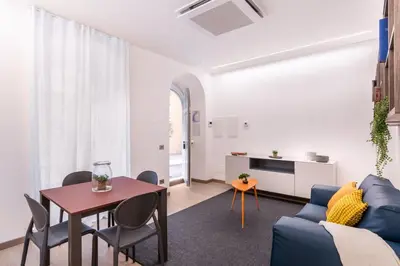 a living room with a blue couch and a table at JOIVY Cavour 238 in Rome