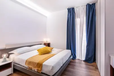 a bedroom with a bed with blue curtains at JOIVY Cavour 238 in Rome