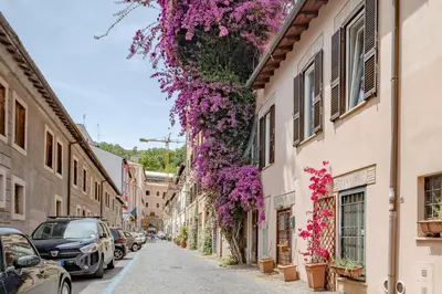 a street with purple flowers hanging from buildings at Apartment B5 in the center of Rome WiFi and AC in Rome