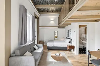 a living room with a couch and a bed at Limehome Rome Via Fortebraccio in Rome