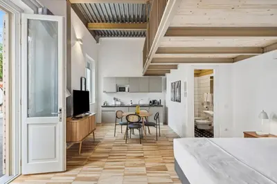 a room with a table and chairs and a kitchen at Limehome Rome Via Fortebraccio in Rome