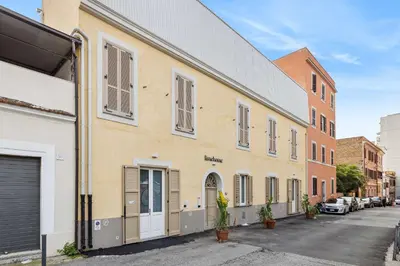 an empty street in front of a building at Limehome Rome Via Fortebraccio in Rome