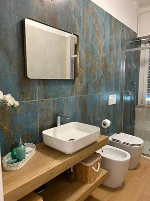 a bathroom with a sink and a toilet and a mirror at Romanamente Suite in Rome