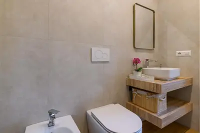 a bathroom with a sink and a toilet and a mirror at Romanamente Suite in Rome
