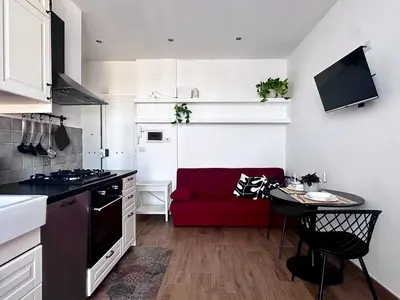 a kitchen with a red couch in a small room at MuMo Home - San Giovanni in Rome