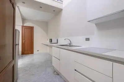 a white kitchen with white cabinets and a sink at Navona New Deluxe Apartment in Rome