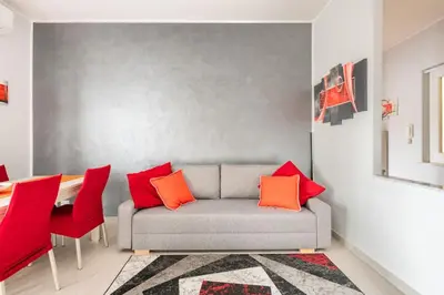 a living room with a couch and red chairs at New and beautiful house in the heart of Rome in Rome