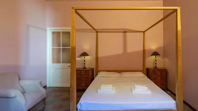 a bedroom with a canopy bed and a couch at EasyTopStay - Campo de' Fiori Pinky House in Rome