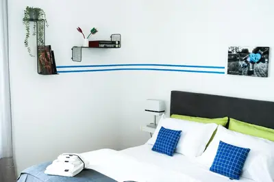 a bedroom with a white bed with blue and green pillows at Milvio22 Apartment in Rome