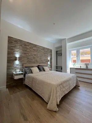 a bedroom with a large bed and a brick wall at dAngelo Apartment Vatican Rome in Rome