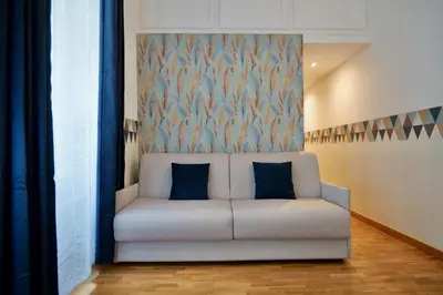a white couch with two blue pillows in a room at Livia86 - Trastevere in Rome