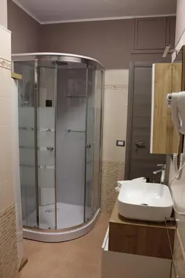 a bathroom with a glass shower and a sink at La Bellavita Trastevere in Rome