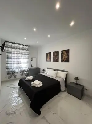 a bedroom with a large bed in a white room at Casa vacanze Flaminia in Rome
