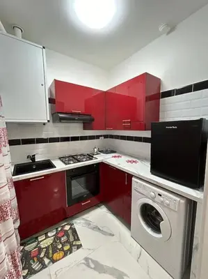 a kitchen with red cabinets and a washing machine at Casa vacanze Flaminia in Rome
