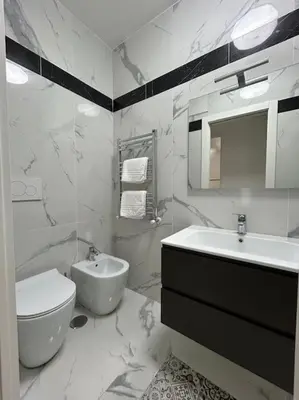 a white bathroom with a sink and a toilet at Casa vacanze Flaminia in Rome