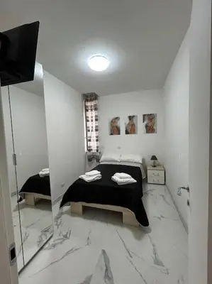 a white bedroom with a bed and a mirror at Casa vacanze Flaminia in Rome
