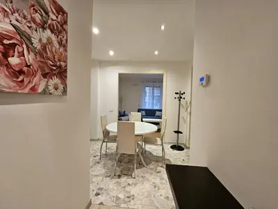 a dining room with a table and a painting on the wall at Be Your Home - Isabella Bright Apartment in Rome