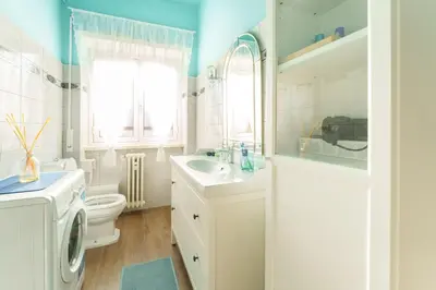 a bathroom with a toilet sink and a washing machine at Good Vibes Vaticano in Rome